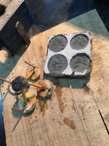 Sand-cast bronze bee pendants. Just poured