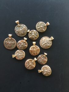 Sand-cast bronze bee pendants with silver rivets